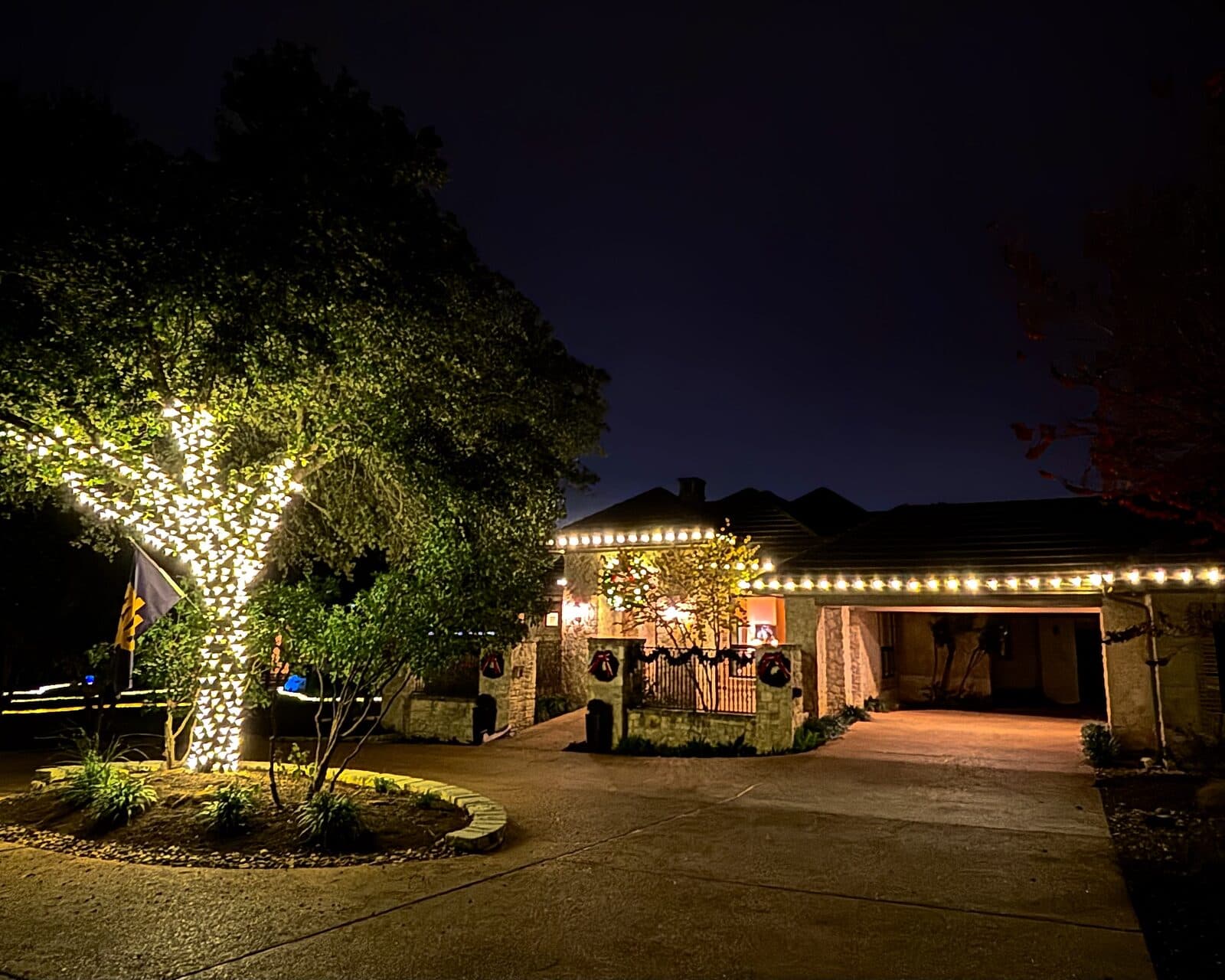 Twilight view of an Atlanta home with warm white roofline Christmas lights