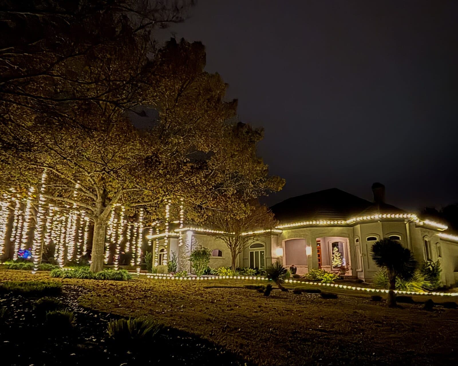 Atlanta home with full Christmas lighting on rooflines, columns, and shrubs