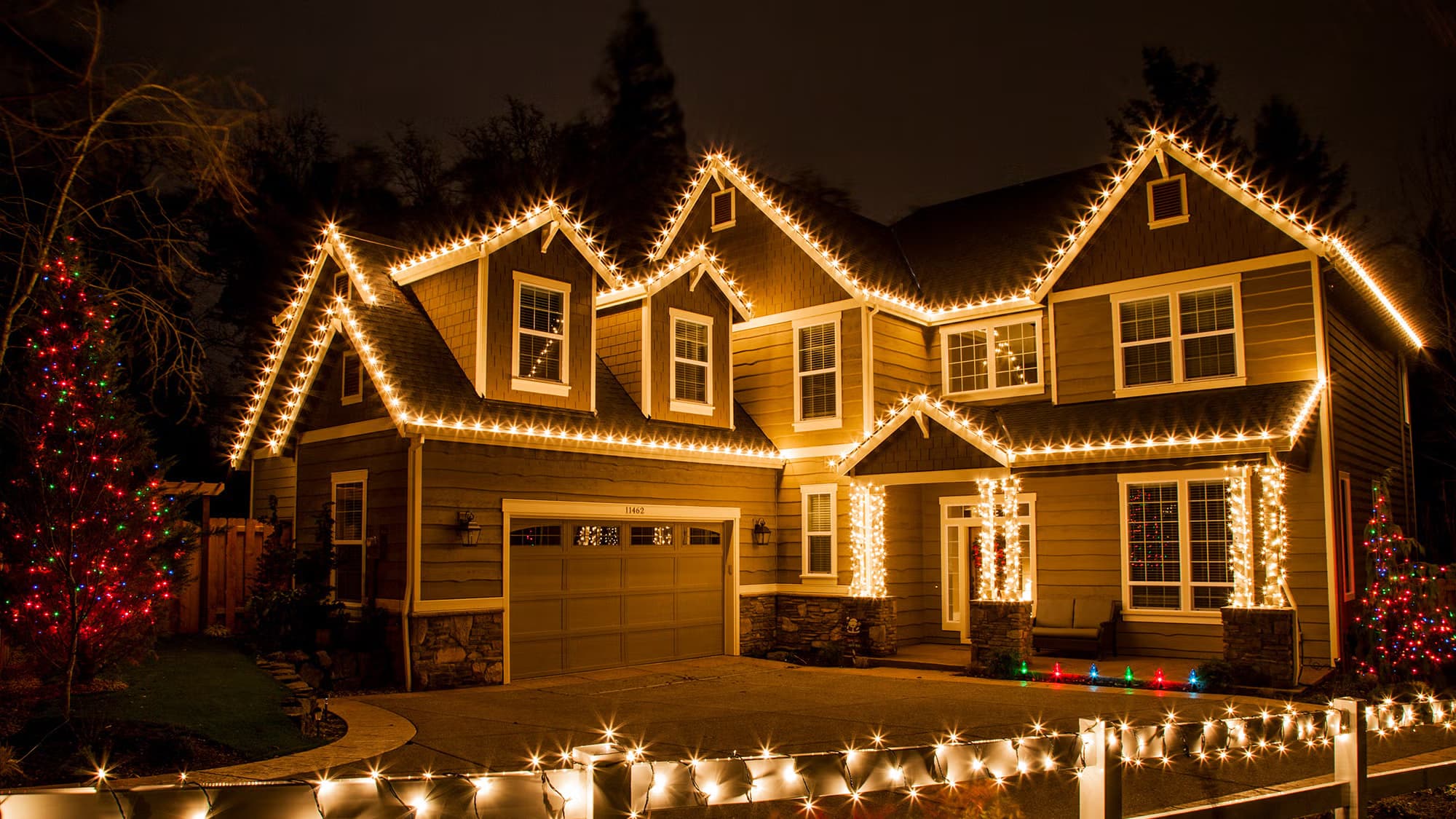Holiday-lit home featured by Atlanta Christmas Lighting Co — full roofline outlining and accent lighting.